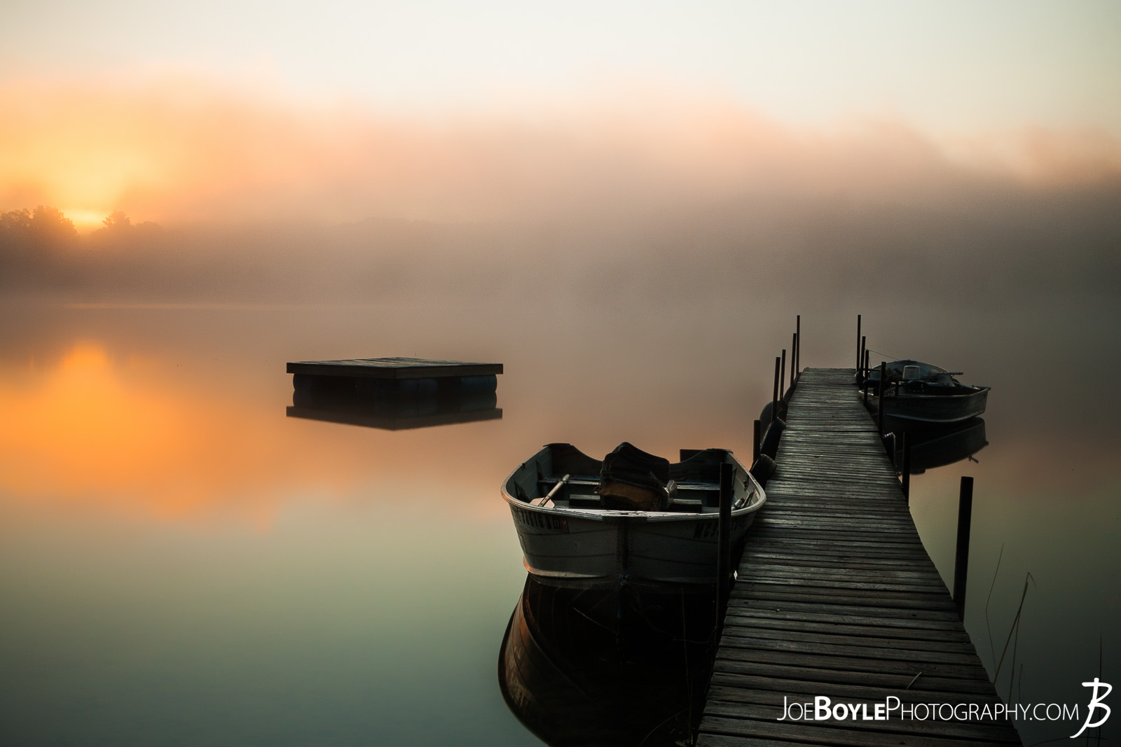  While on a trip up to Big Bass Lake, Michigan spending time with friends, fishing, having bonfires and what not, I was able to take this beautiful sunrise photo! I really love how the pier and boats were so still in the water. 