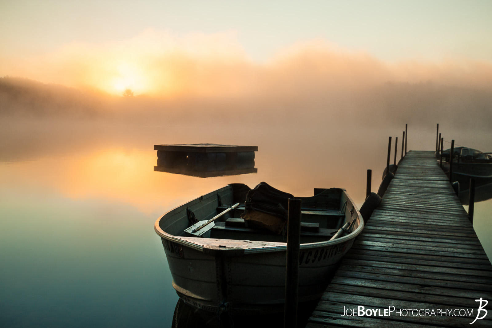  While on a trip up to Big Bass Lake, Michigan spending time with friends, fishing, having bonfires and what not, I was able to take this beautiful sunrise photo! I really love how the pier and boats were so still in the water. 