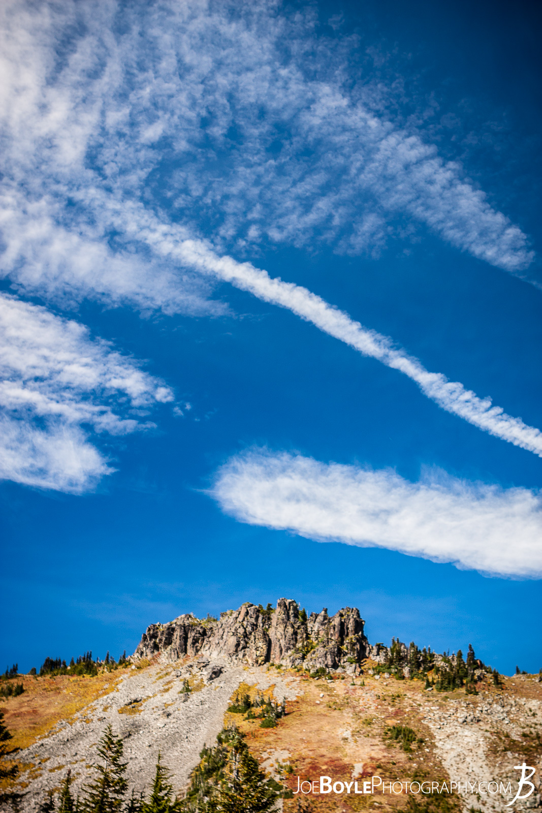  After we left Mowich Lake Campground, my buddy and I decided to take the Spray Park trail instead of the Wonderland Trail Proper. I read in Bette Filley's book, "Discovering The Wonders of the Wonderland Trail" that Spray Park offers some magnificent views whereas the Wonderland Trail is more forested and covered. The only catch is that if it's bad weather, Spray Park is absolutely miserable as there is no cover and it's the highest point on the trail. Thankfully we lucked out and had blue skies and great views! Here is a photo of Hessong Rock as seen from the Spray park Trail. 