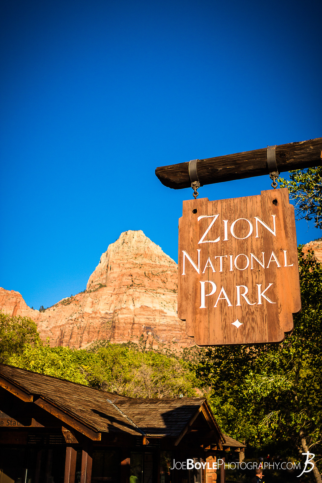  Here is a photo of the sign at the entrance of Zion National Park with a canyon in the background and a beautiful blue sky!  Here are some links to more articles and hiking info about the West Rim Trail and hiking trails in Zion National Park and a Map of Zion National Park. 