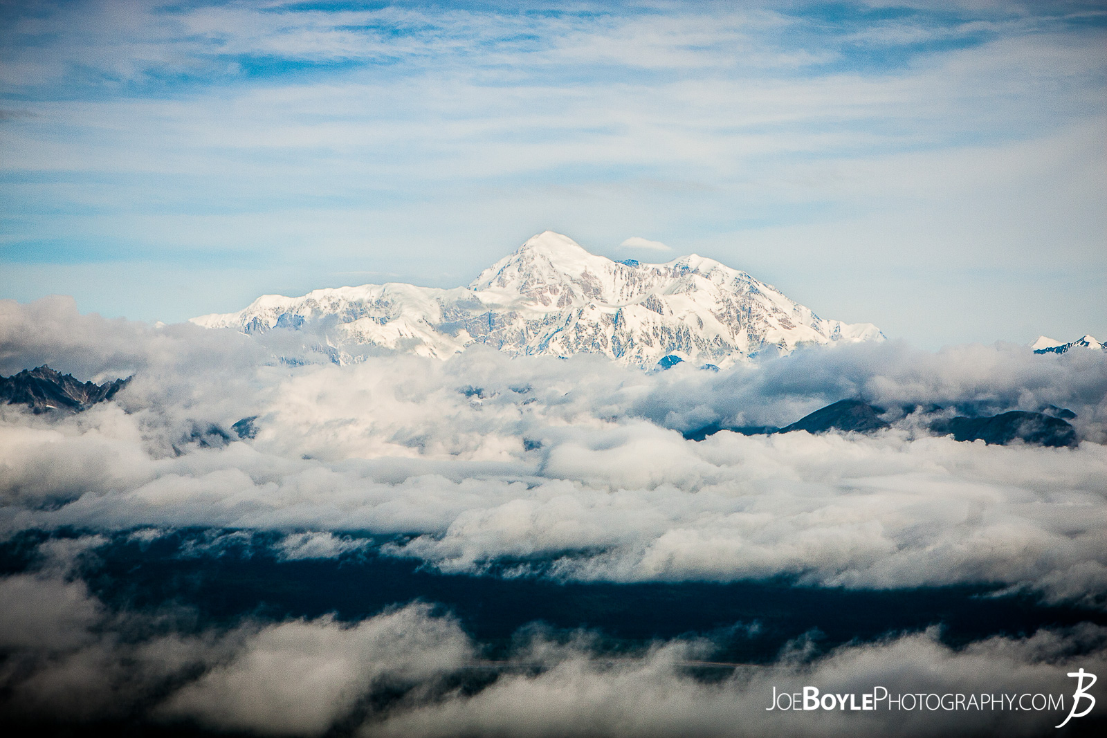  I was thrilled to be able to go to Alaska for some extended backpacking! A good buddy of mine and myself spent 17 days backing and traveling throughout different parks in Alaska. From ridge trails and Denali National Park (formerly McKinley National Park) to Kennicot and Wrangel-St. Elias, we covered a lot of ground in a short time!  I took this photo of Mount Denali at the top of the first steep climb on the Kesugi Ridge Trail! At this point in the day some clouds moved in that provided a really cool and dramatic setting! This trail is located in Denali State Park which is just an hour or two south of Denali National Park! This trail offered some fantastic views of Mt. Denali and the surrounding mountains, forests and meadows! We spent 2 nights on this trail and it was a lot of fun! The landscape was always changing as we hiked up the mountain, onto the ridge and back down again! 