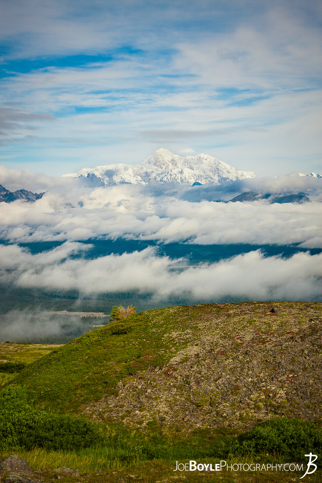  I was thrilled to be able to go to Alaska for some extended backpacking! A good buddy of mine and myself spent 17 days backing and traveling throughout different parks in Alaska. From ridge trails and Denali National Park (formerly McKinley National Park) to Kennicot and Wrangel-St. Elias, we covered a lot of ground in a short time!  I took this photo of Mount Denali at the top of the first steep climb on the Kesugi Ridge Trail! At this point in the day some clouds moved in that provided a really cool and dramatic setting! This trail is located in Denali State Park which is just an hour or two south of Denali National Park! This trail offered some fantastic views of Mt. Denali and the surrounding mountains, forests and meadows! We spent 2 nights on this trail and it was a lot of fun! The landscape was always changing as we hiked up the mountain, onto the ridge and back down again! 