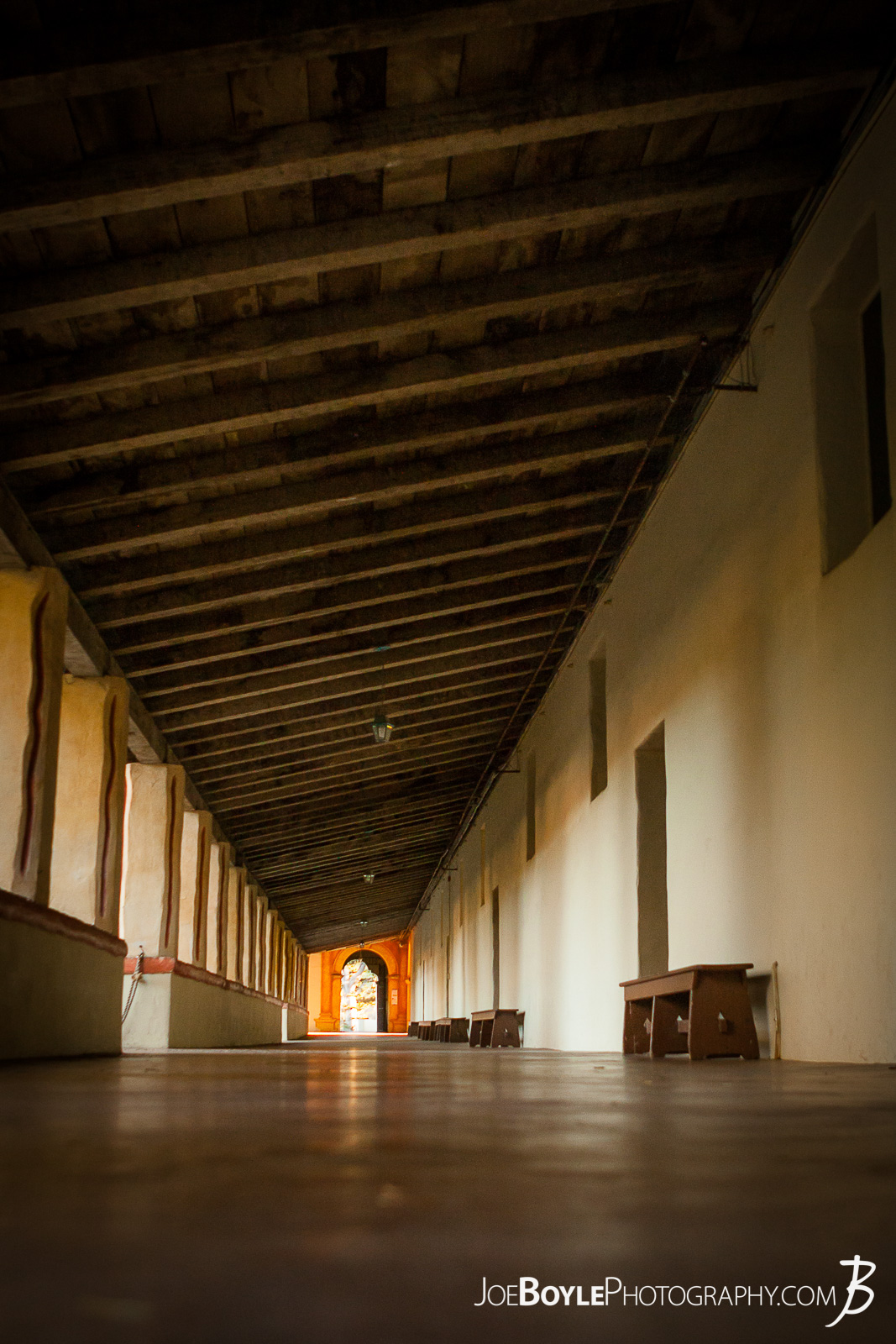  While visiting Carmel by the Sea, my friends and I stopped over at the Carmel Mission Basilica. This is a photo of the hallway at the mission. I really like the repeating wood rafters and long hallway! 